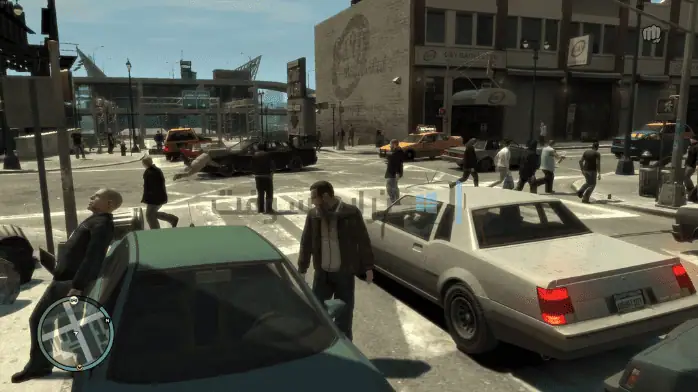 صورة من لعبة GTA IV على الكمبيوتر الشخصي، تسلط الضوء على لحظة مليئة بالإثارة مع الشخصيات التي تتنقل في منطقة حضرية صاخبة.