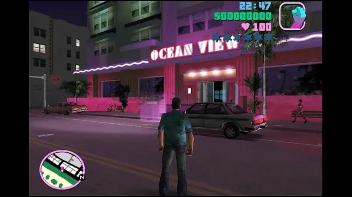 لقطة شاشة للعبة GTA Vice City على الكمبيوتر الشخصي، تعرض مناظر المدينة النابضة بالحياة وأشجار النخيل والرسومات ذات الطراز القديم.